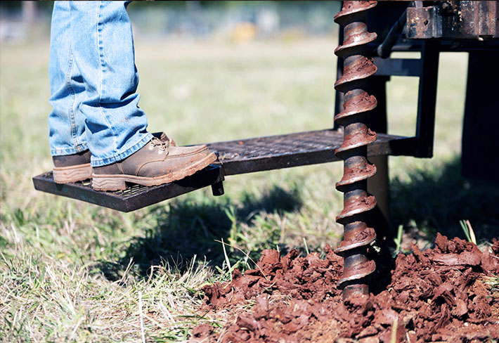 Worker using auger.